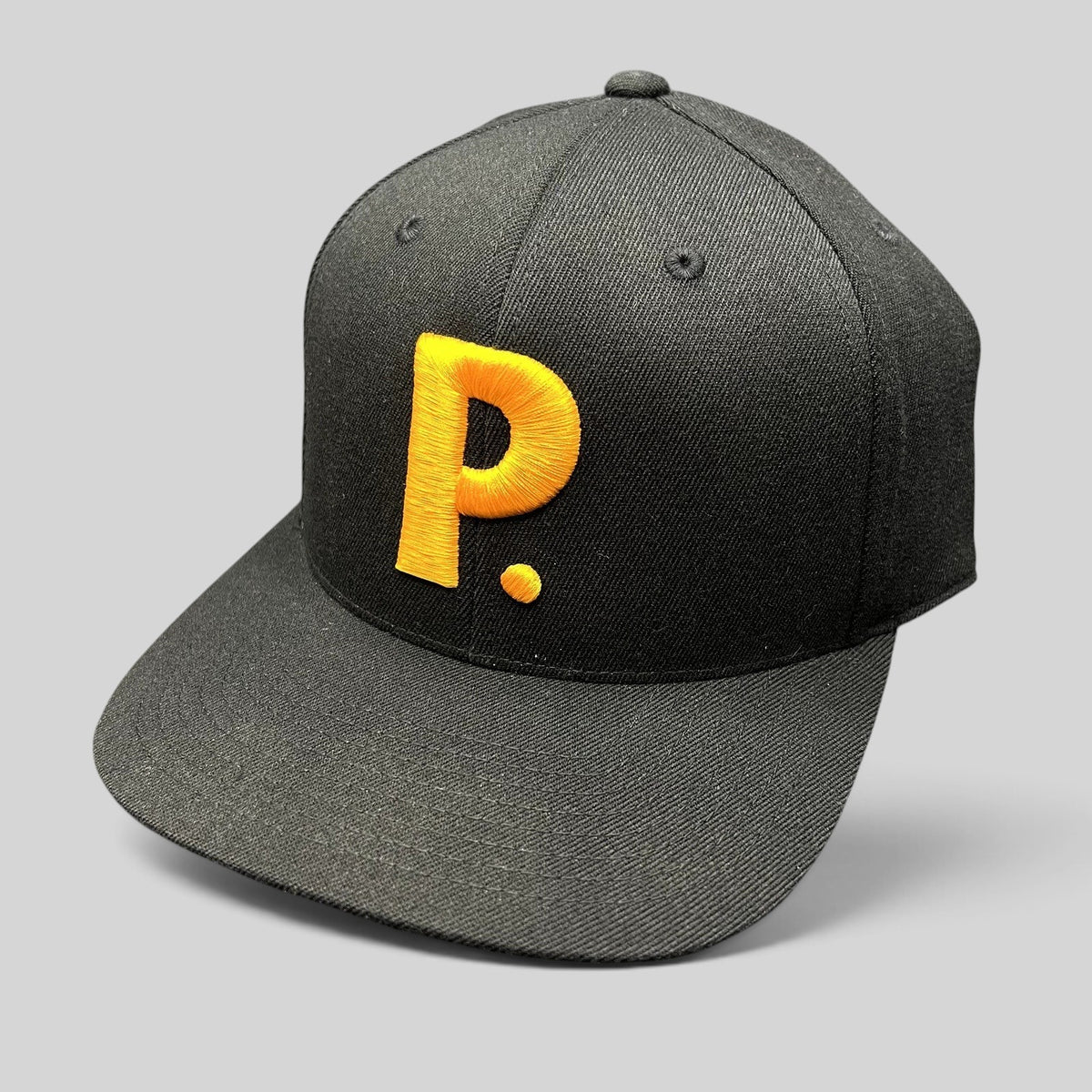 Raree Finds black Yupoong 110 Flexfit snapback hat featuring a bold gold embroidered P logo on the front crown.