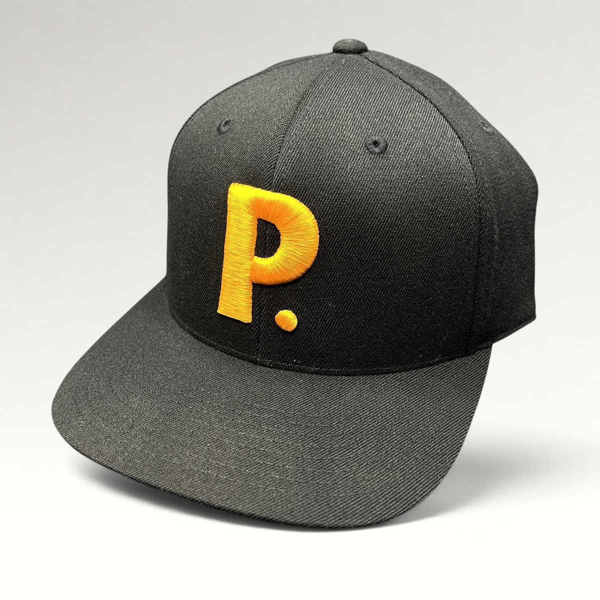 Raree Finds black Yupoong 110 Flexfit snapback hat featuring a bold gold embroidered P logo on the front crown.