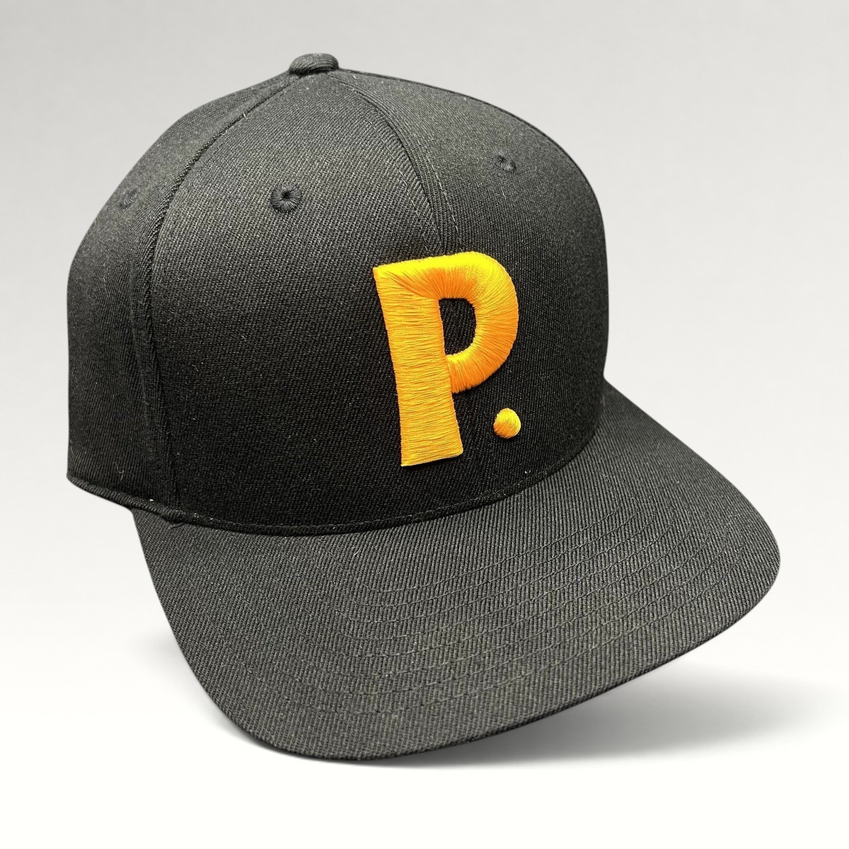 Raree Finds black Yupoong 110 Flexfit snapback hat featuring a bold gold embroidered P logo on the structured crown