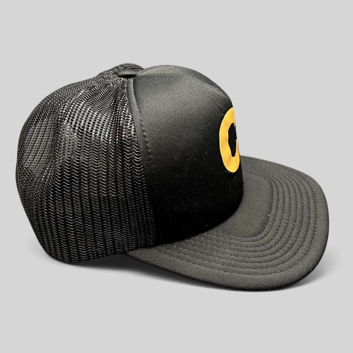Raree Finds Cloud 10 C10 black and gold trucker hat with foam front, mesh back panels, and structured high crown.