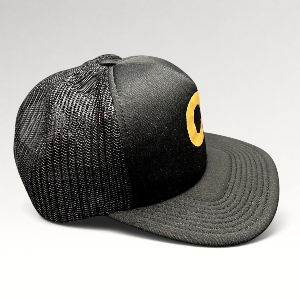 Raree Finds Cloud 10 C10 black and gold trucker hat with foam front, mesh back panels, and structured high crown.
