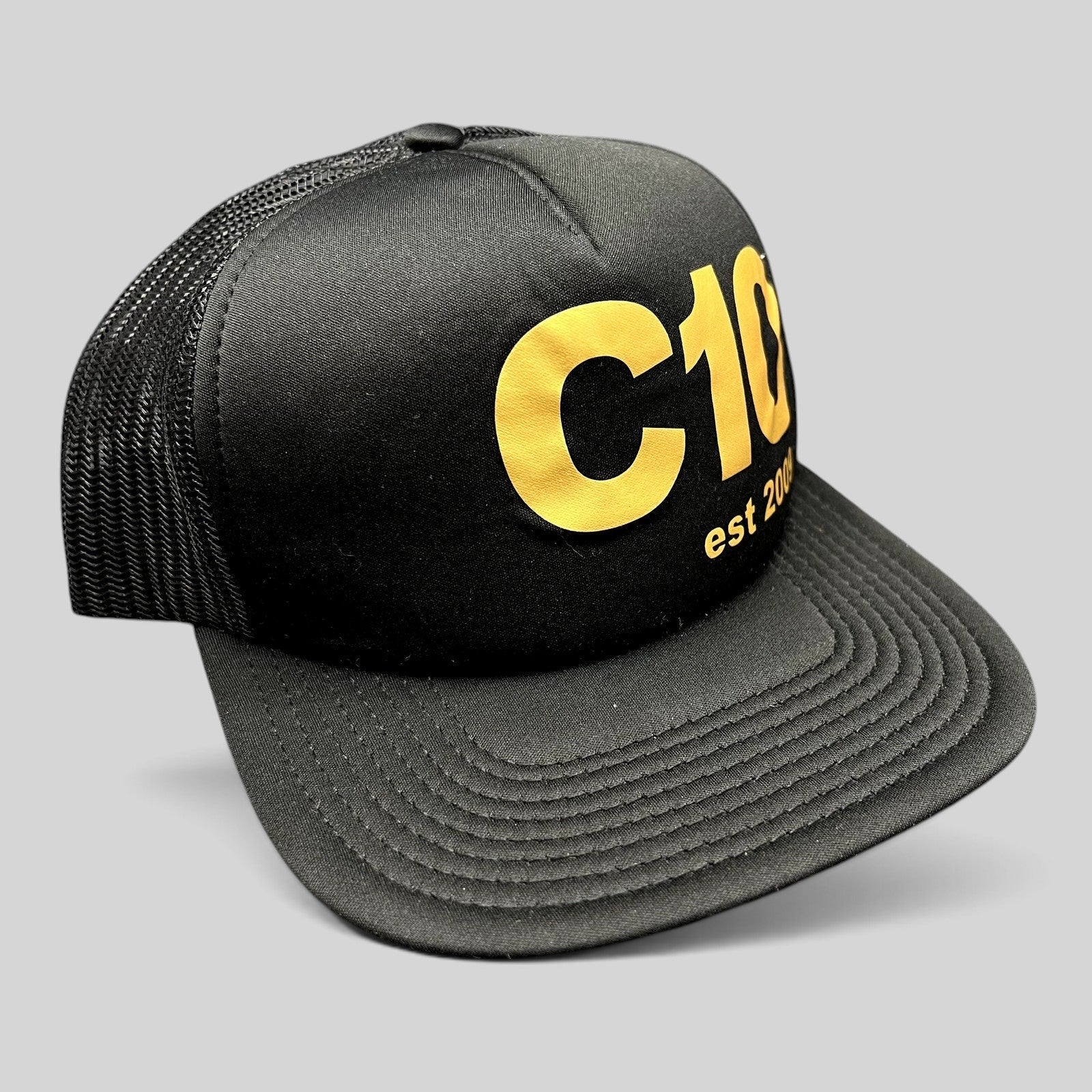 Raree Finds black and gold C10 trucker snapback hat with a structured foam front and breathable mesh back panels.