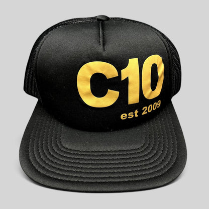 Raree Finds black Otto trucker snapback hat with gold C10 graphic and mesh back panels.