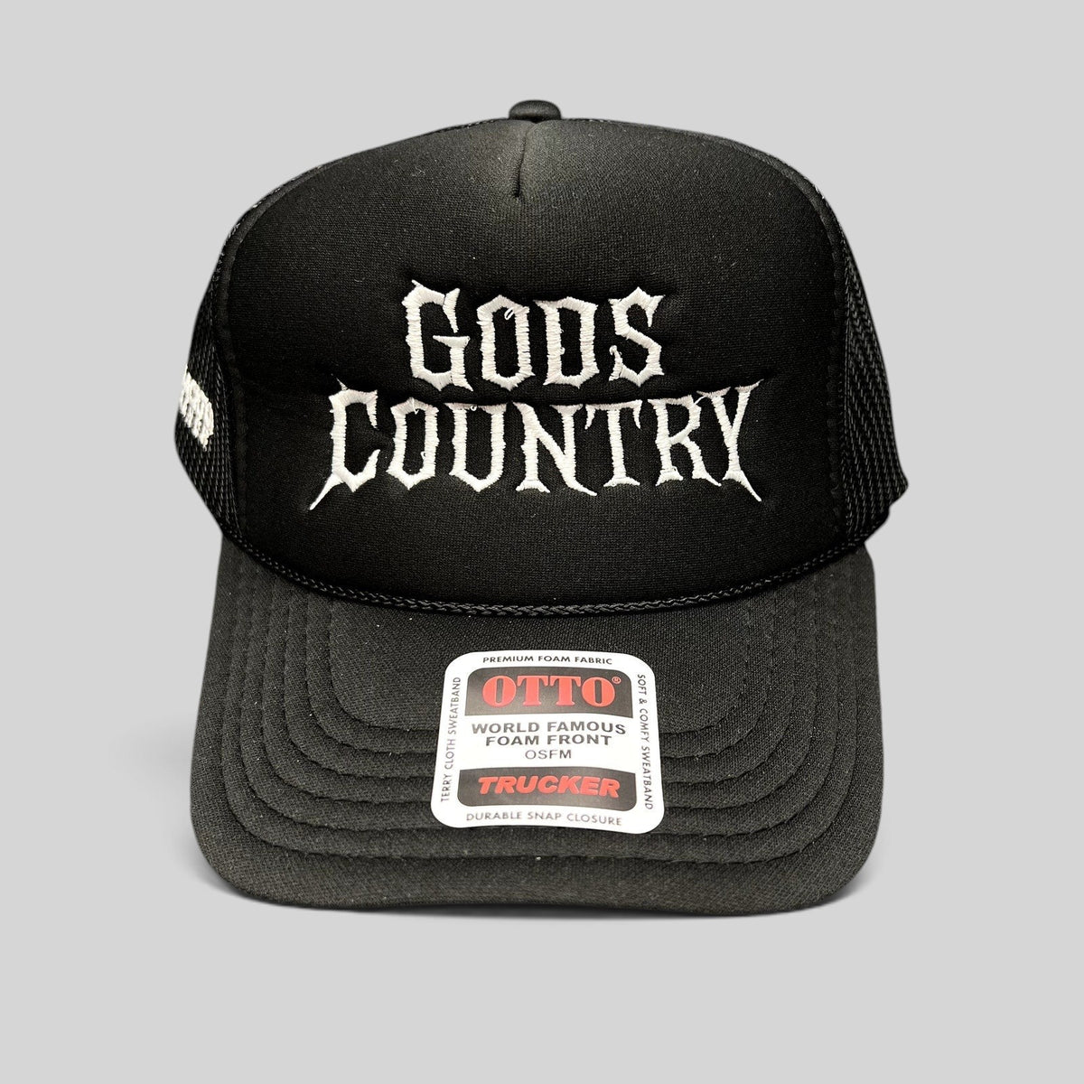 Raree Finds black trucker hat with white gothic God's Country embroidery, foam front, and mesh back.