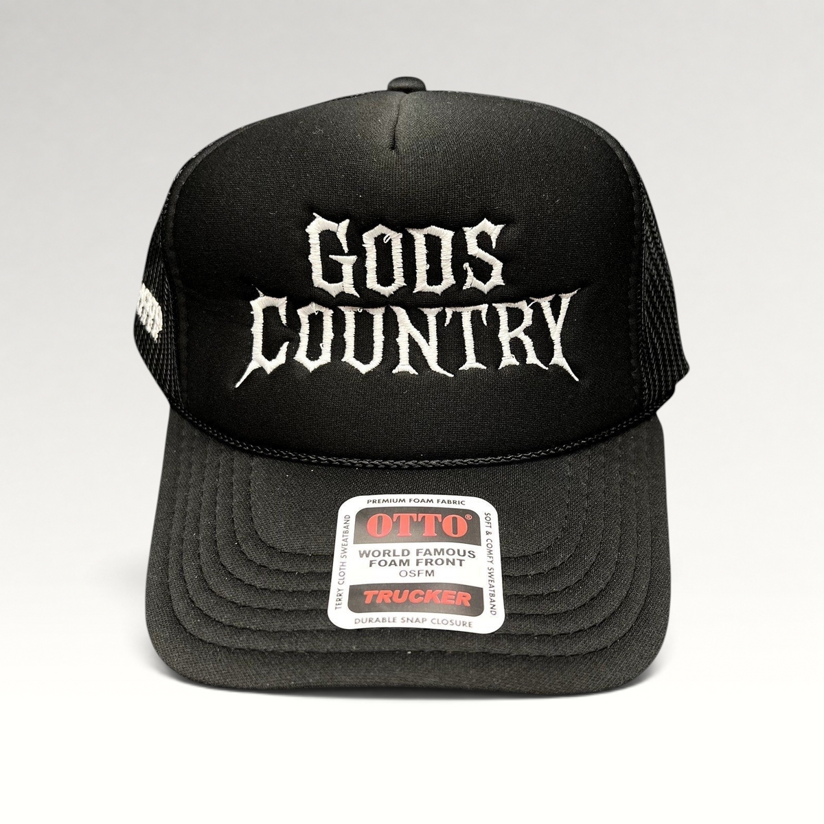 Raree Finds black trucker hat with white gothic God's Country embroidery, foam front, and mesh back.