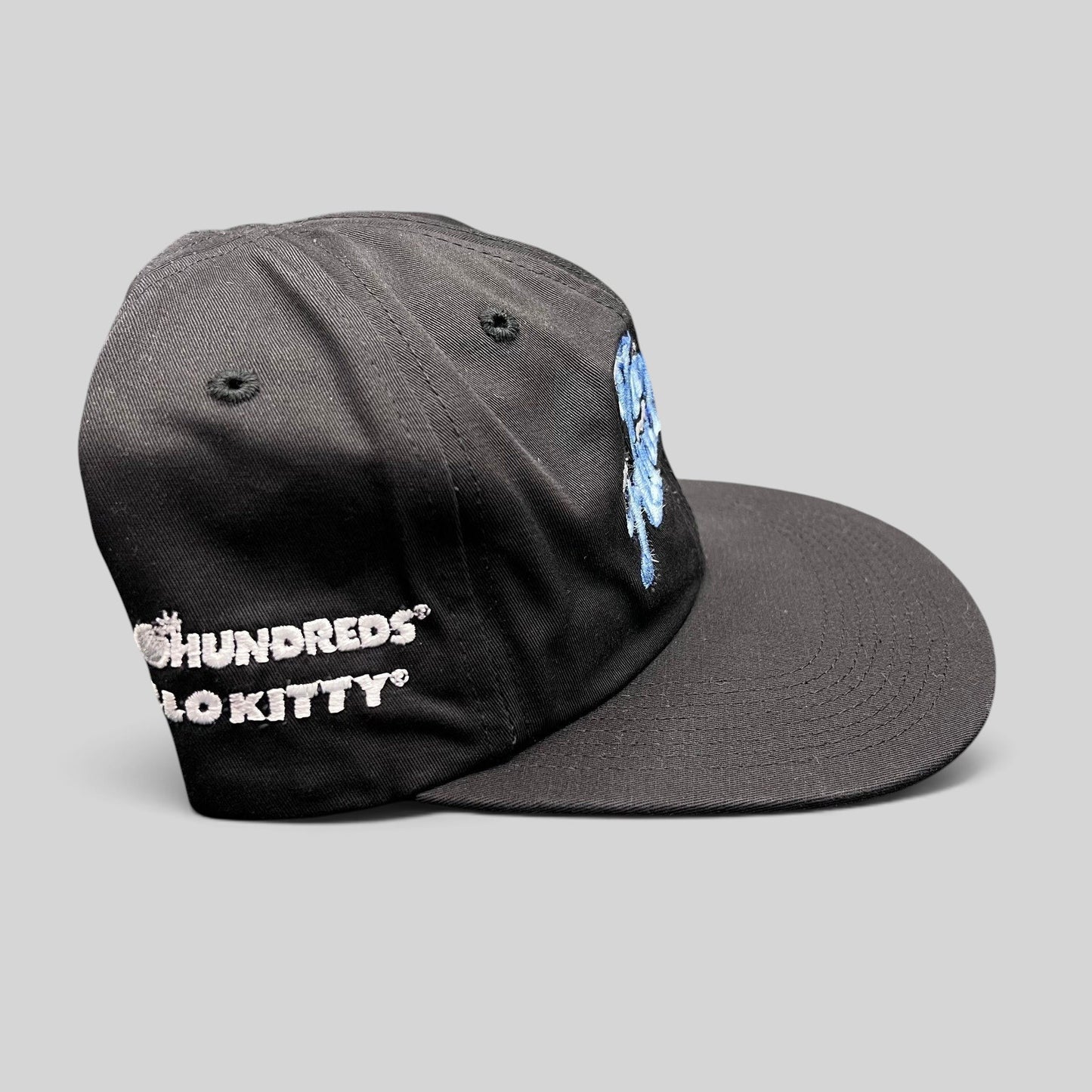 Raree Finds black cotton snapback hat from The Hundreds x Hello Kitty collaboration with blue and white embroidery.