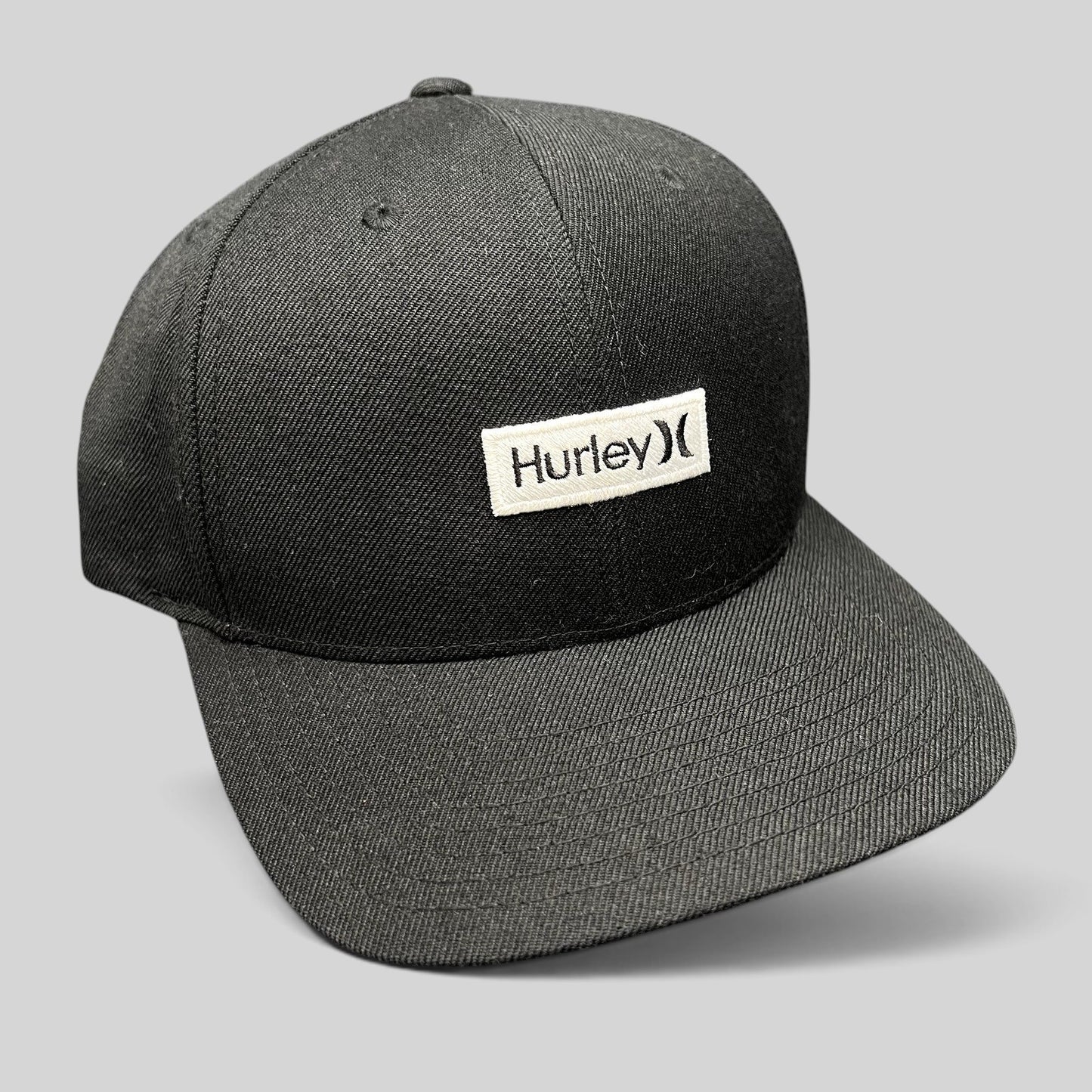Raree Finds black Hurley snapback hat with a woven logo patch on a structured Yupoong The Classics crown.