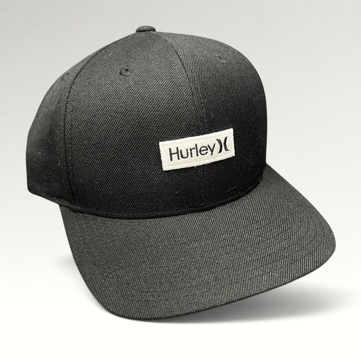 Raree Finds black Hurley snapback hat with a woven logo patch on a structured Yupoong The Classics crown.