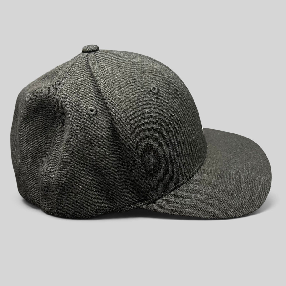 Raree Finds black Kangol flexfit baseball cap with a structured crown and curved brim in a side profile view.