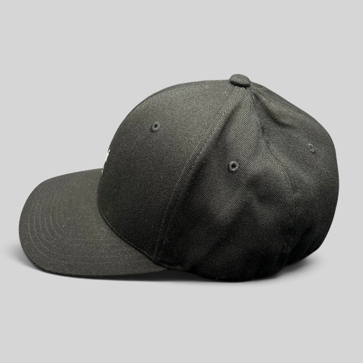 Raree Finds black Kangol flexfit baseball cap with a structured crown and curved brim shown from the side profile.