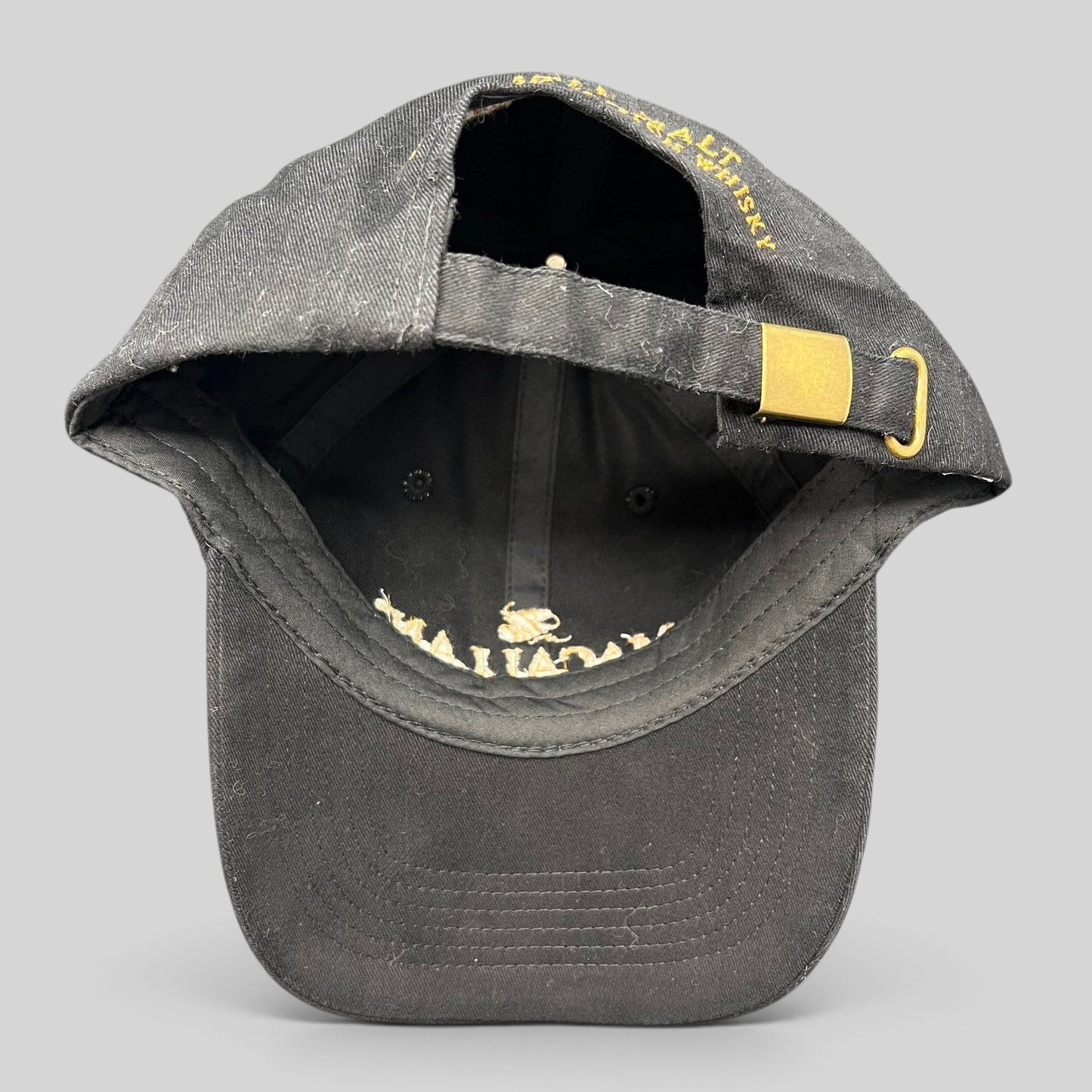 Raree Finds black Macallan Scotch Whisky strapback hat with gold metal buckle closure and embroidered logo detail