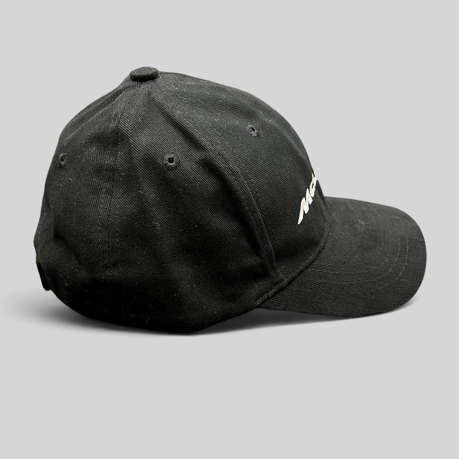 Raree Finds black McLaren cotton strapback hat with white embroidered logo, side profile view of 6-panel cap.