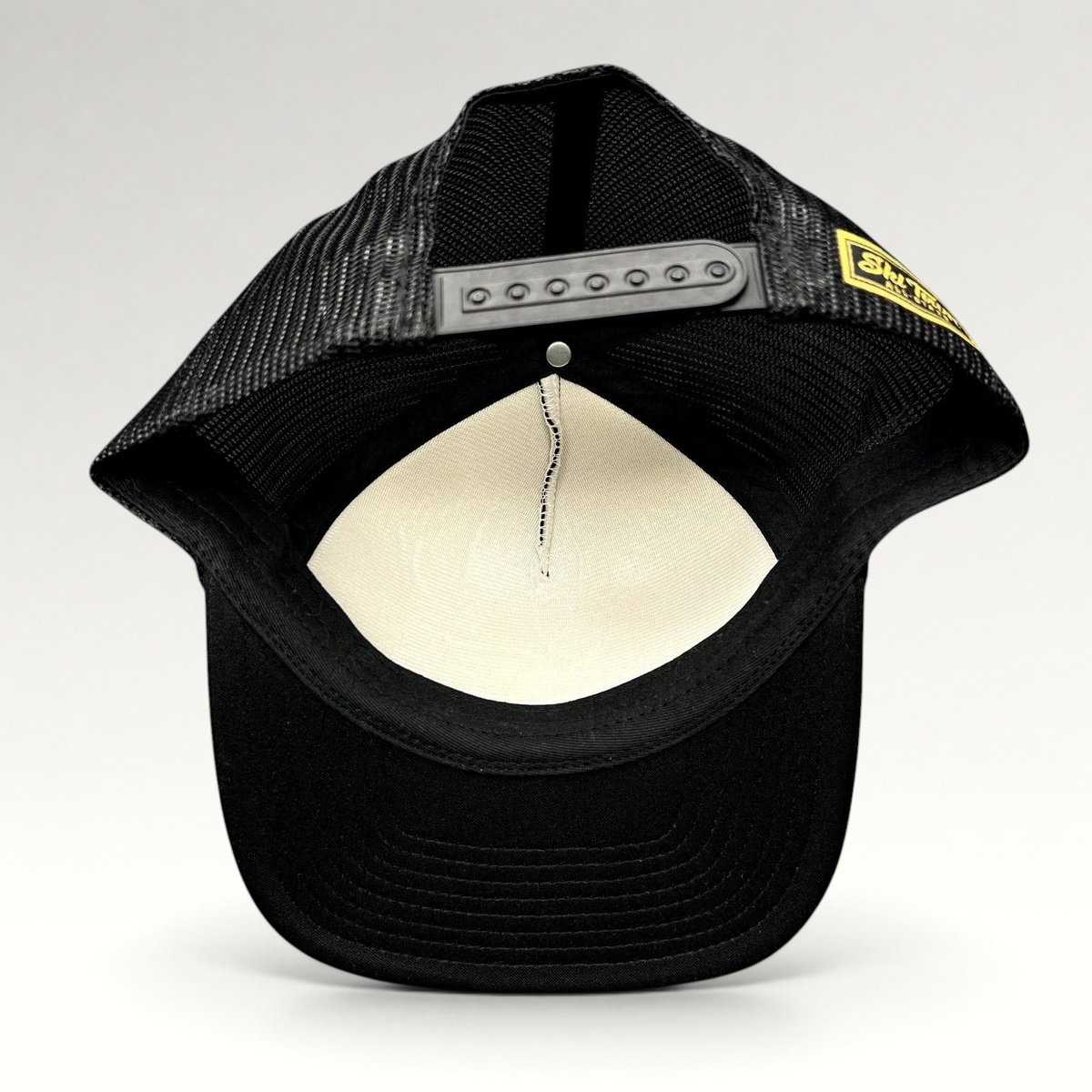 Raree Finds black mesh trucker hat with adjustable snapback closure and interior foam lining, back view