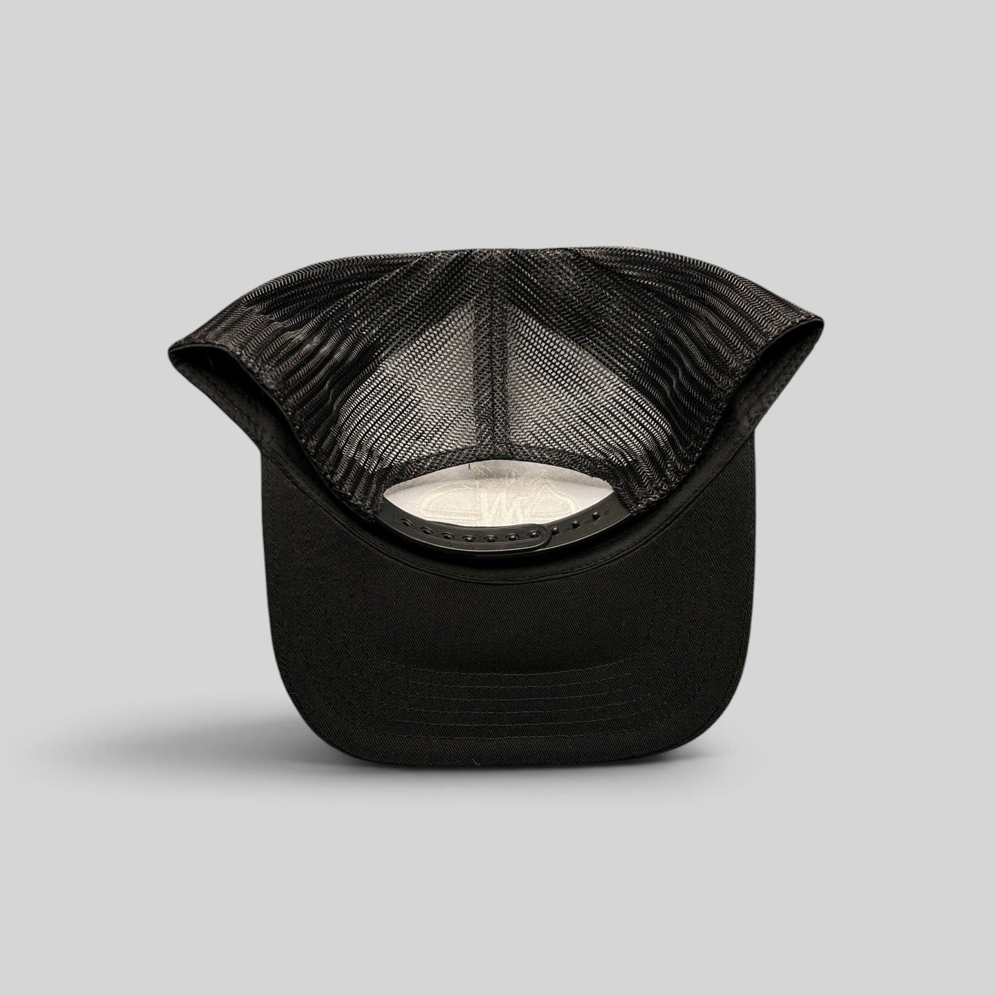 Raree Finds black mesh trucker hat with adjustable snapback closure seen from the back interior view
