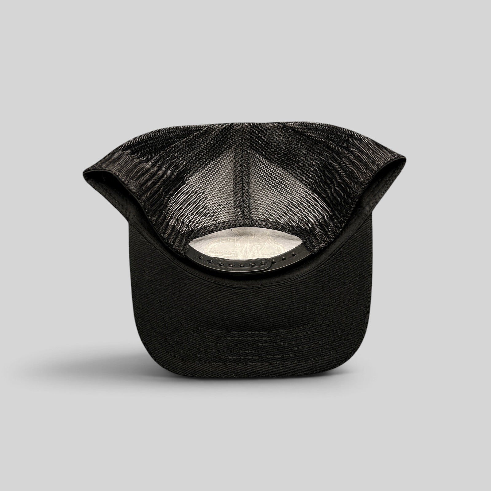 Raree Finds black mesh trucker hat with adjustable snapback closure seen from the back interior view