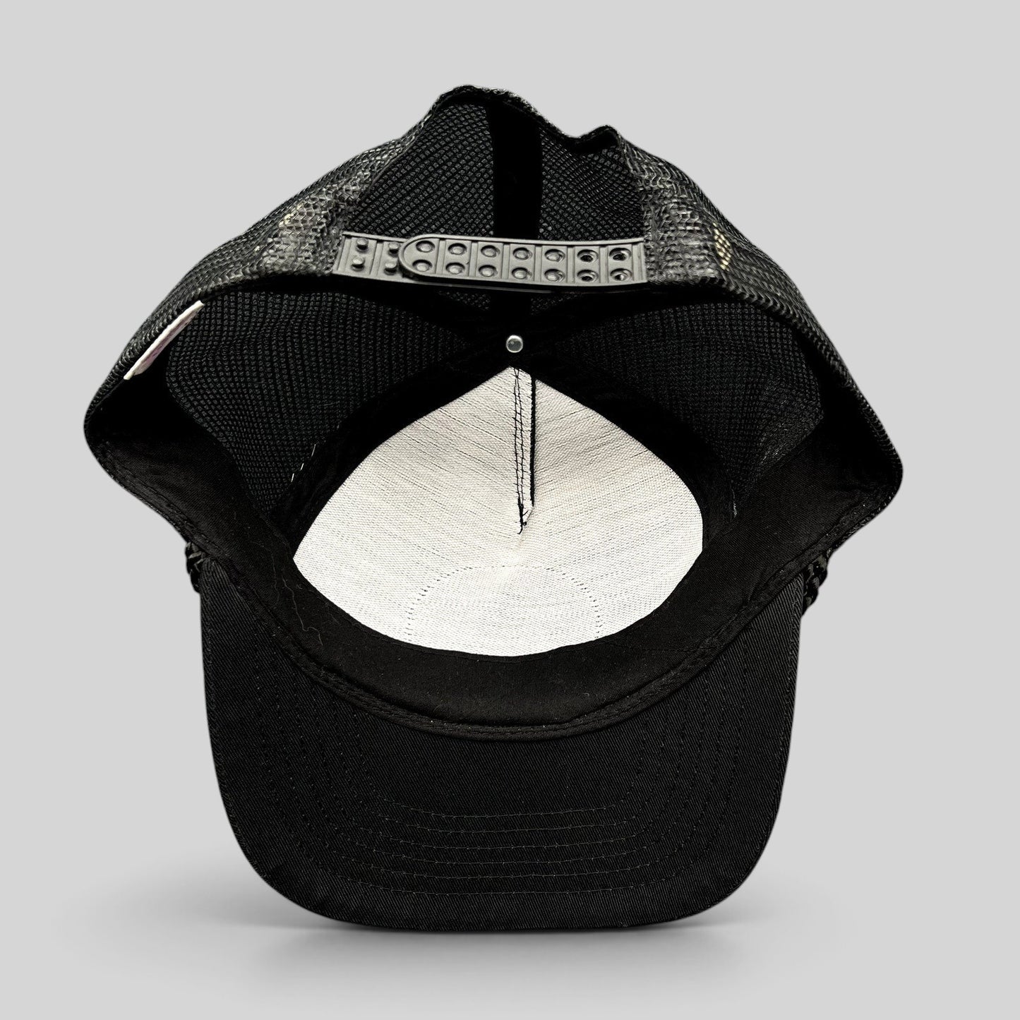 Raree Finds vintage black mesh trucker hat showing the interior foam lining and adjustable snapback closure