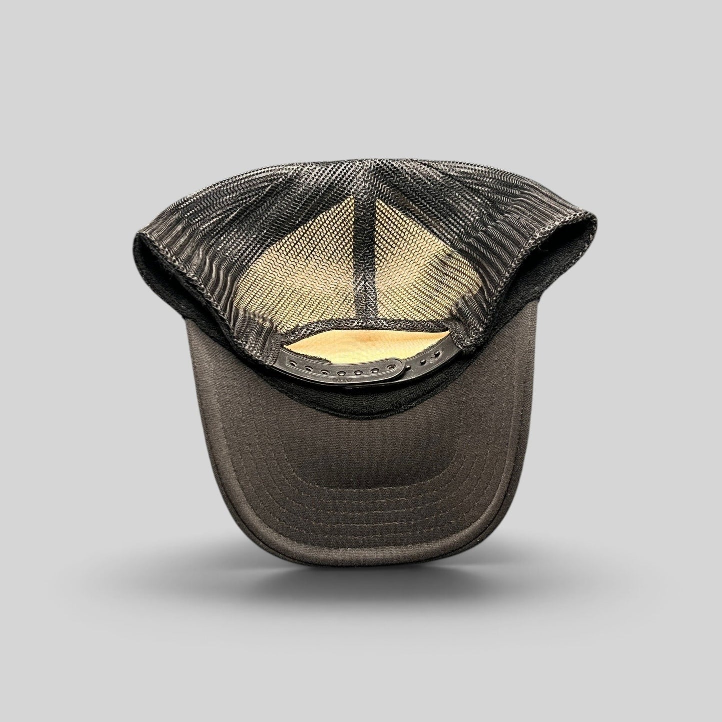 Raree Finds black trucker hat with breathable mesh back and adjustable snapback closure viewed from the rear