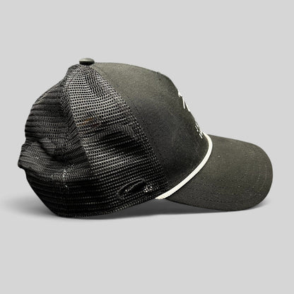Raree Finds black trucker hat with mesh back, white embroidered coastal logo, and adjustable snapback closure.