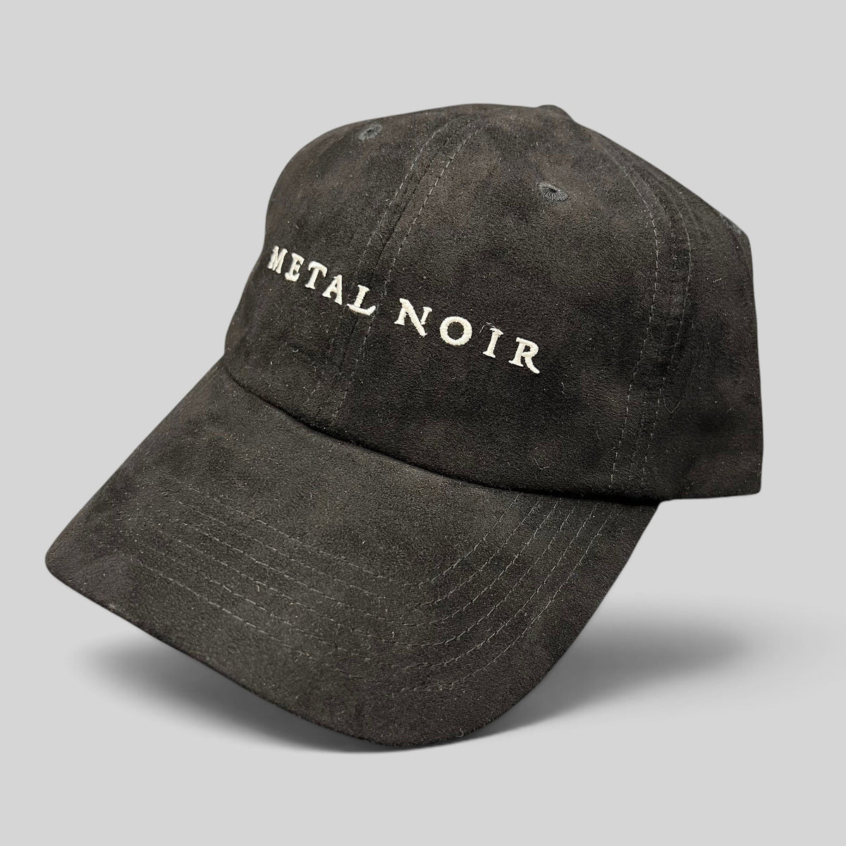 Raree Finds black unstructured strapback hat with white Metal Noir embroidery and a soft suede-like cotton finish.