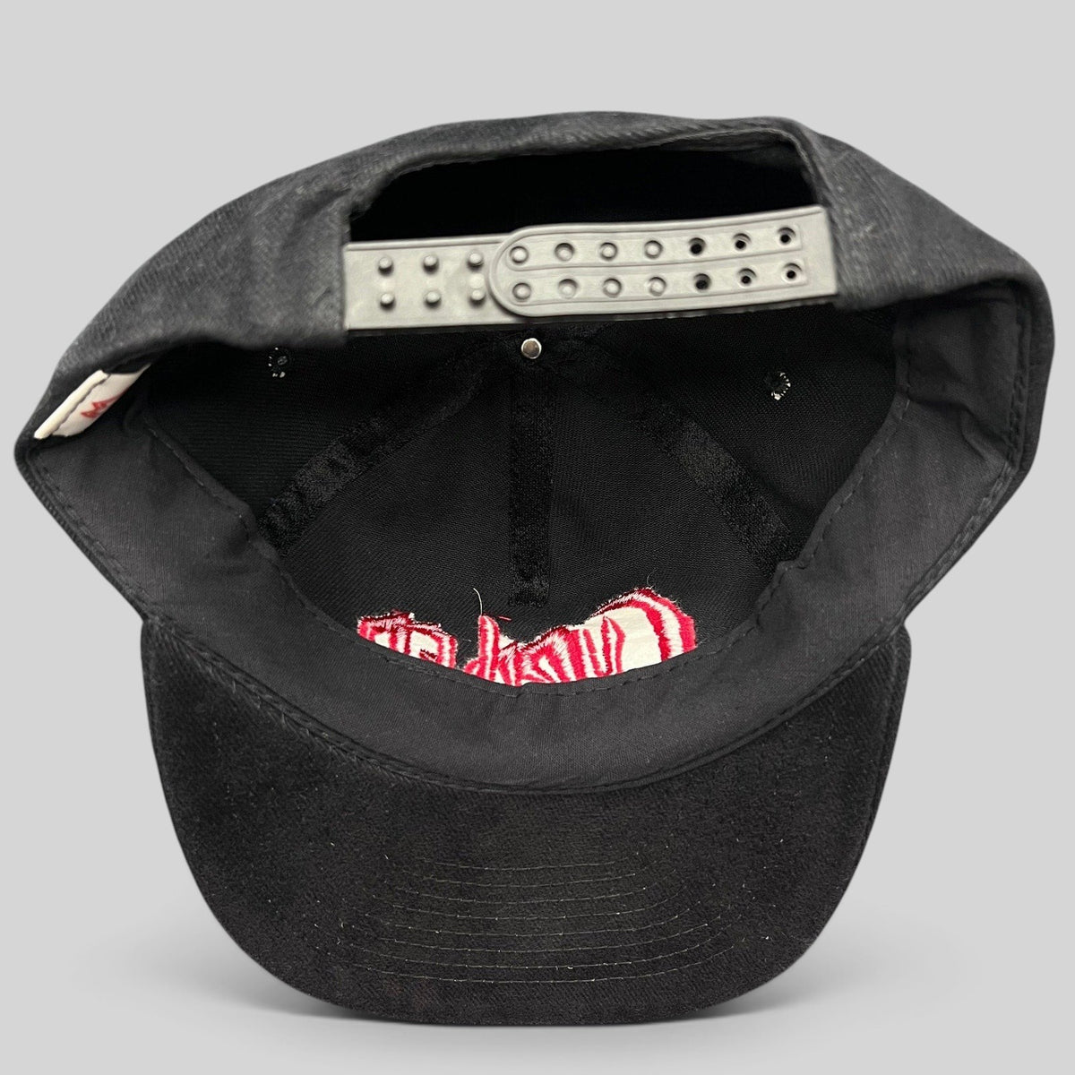 Raree Finds black cotton snapback hat with red Curdled metal band logo embroidery, showing adjustable back strap.