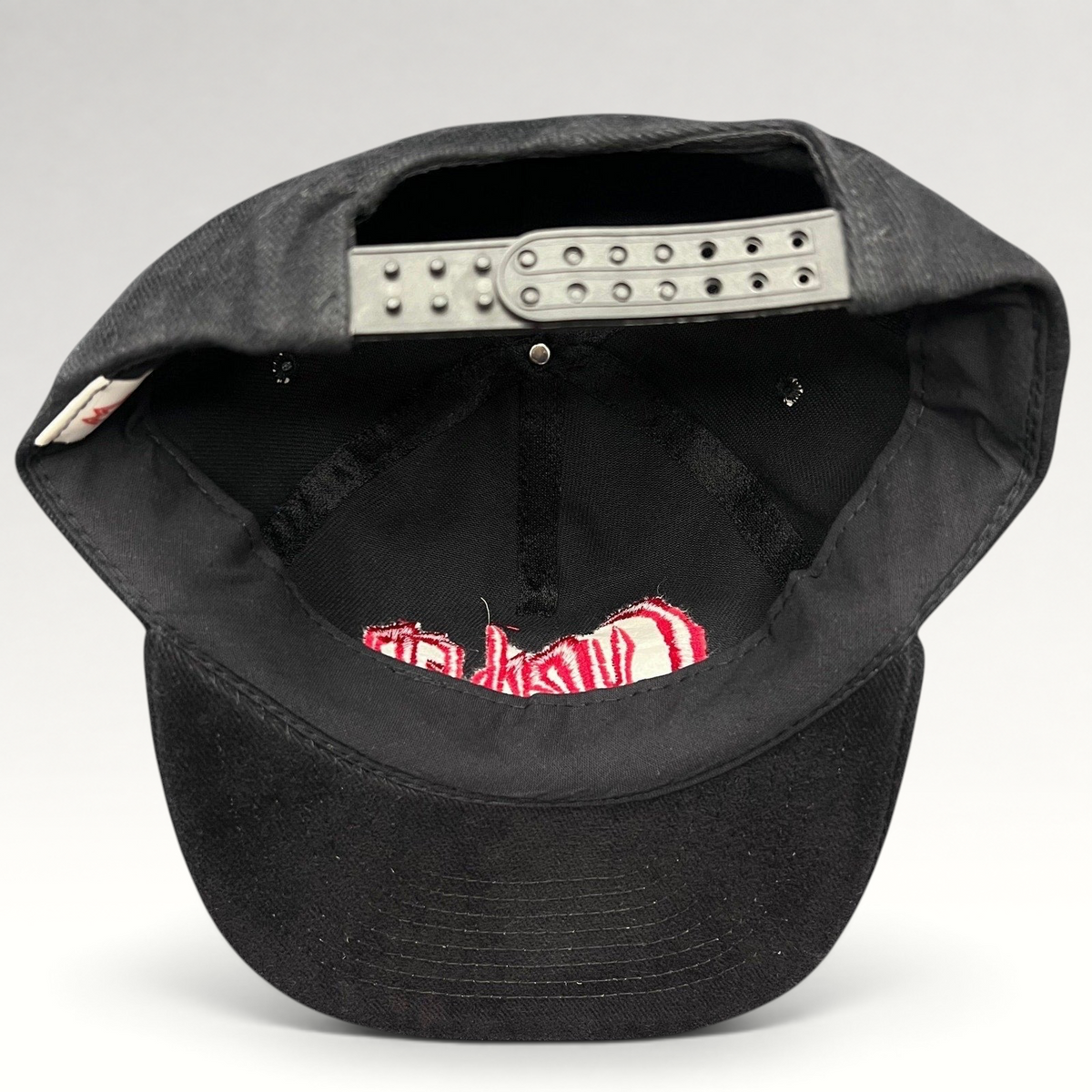 Raree Finds black cotton snapback hat with red Curdled metal band logo embroidery, showing adjustable back strap.