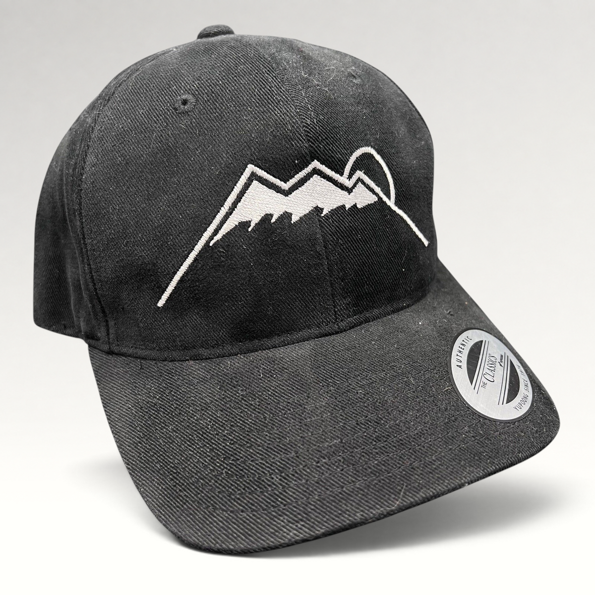Raree Finds black Yupoong strapback hat featuring a white embroidered Humphreys Peak mountain and sun graphic.