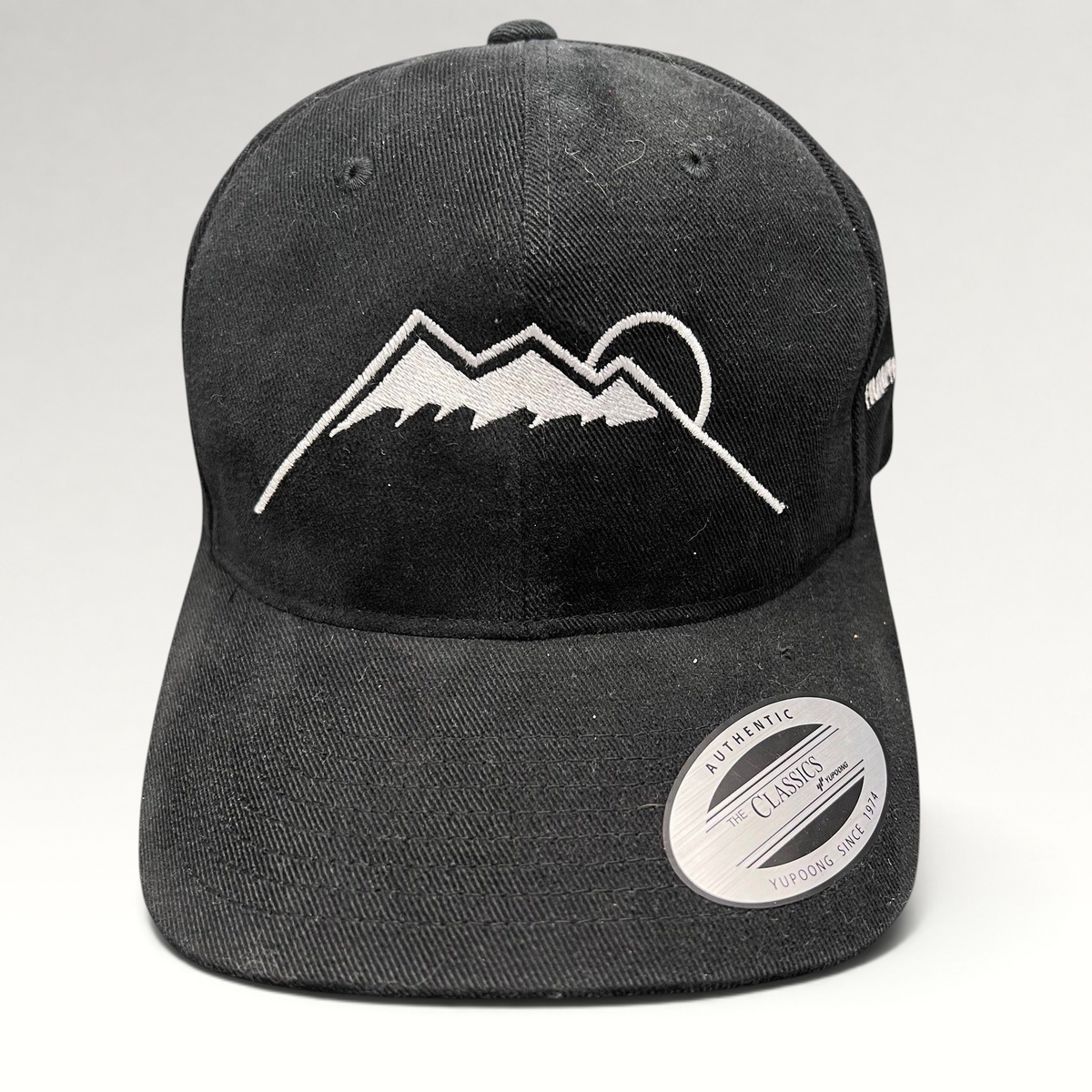 Raree Finds black Yupoong strapback hat featuring a white embroidered Humphreys Peak mountain and sun graphic