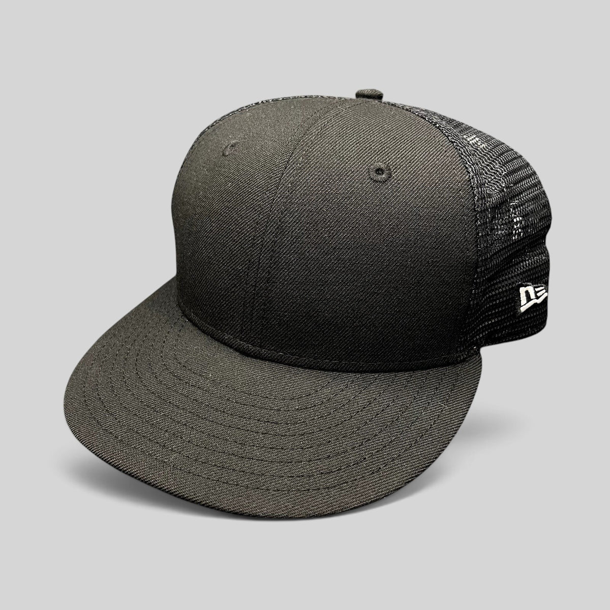 Raree Finds black New Era 59FIFTY fitted trucker hat with a high crown, flat brim, and breathable mesh back panels.