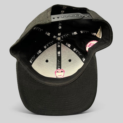Raree Finds black New Era 9FIFTY snapback hat showing the interior crown with branded taping and pink logo embroidery.