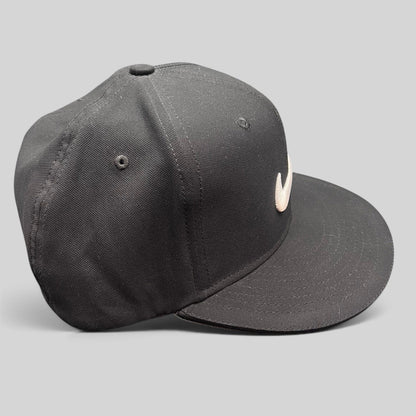 Raree Finds black Nike Golf fitted cap with white embroidered Swoosh logo and flat brim, side view.