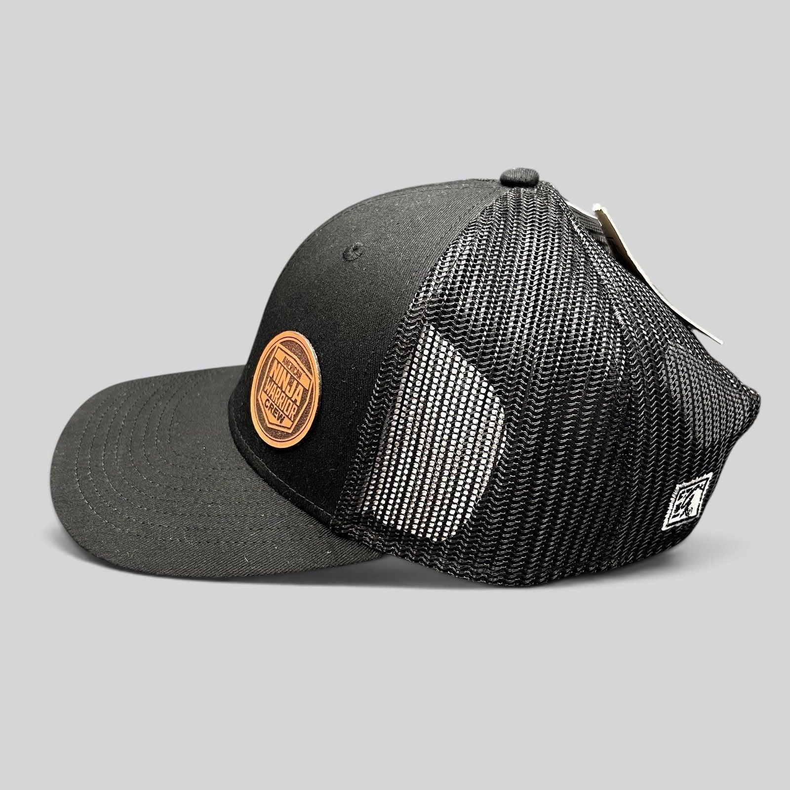 Raree Finds black American Ninja Warrior crew trucker hat with a leatherette patch and mesh back panels.