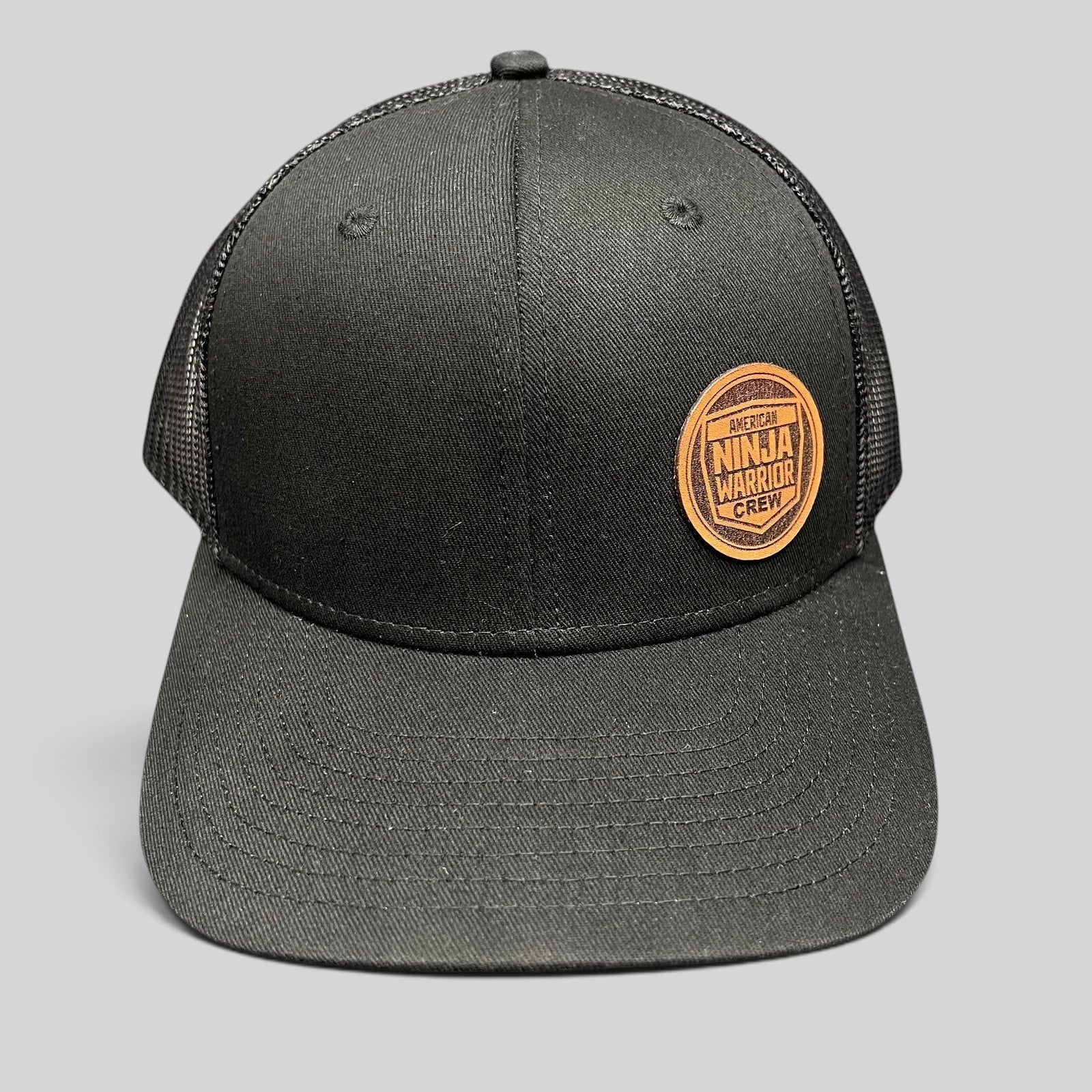 Raree Finds black American Ninja Warrior Crew trucker snapback hat with a round leatherette patch and mesh back.
