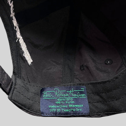 Raree Finds black nylon hat interior label showing brand details and UPF 50 fabric specifications