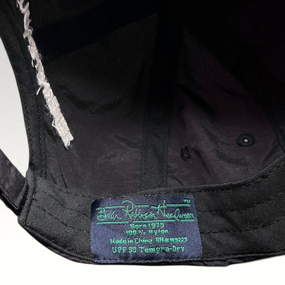 Raree Finds black nylon hat interior label showing brand details and UPF 50 fabric specifications