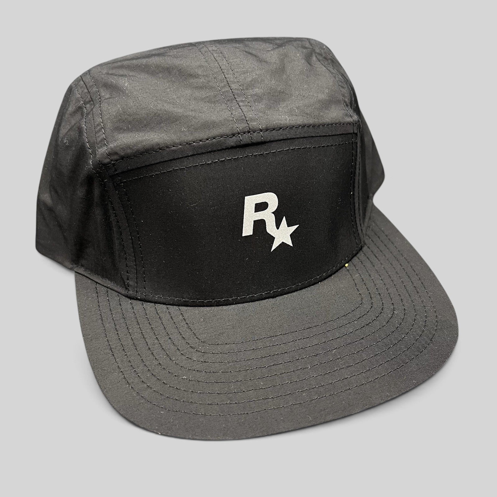 Raree Finds black nylon 5-panel camp hat featuring a white Rockstar Games logo on the front with a flat brim.
