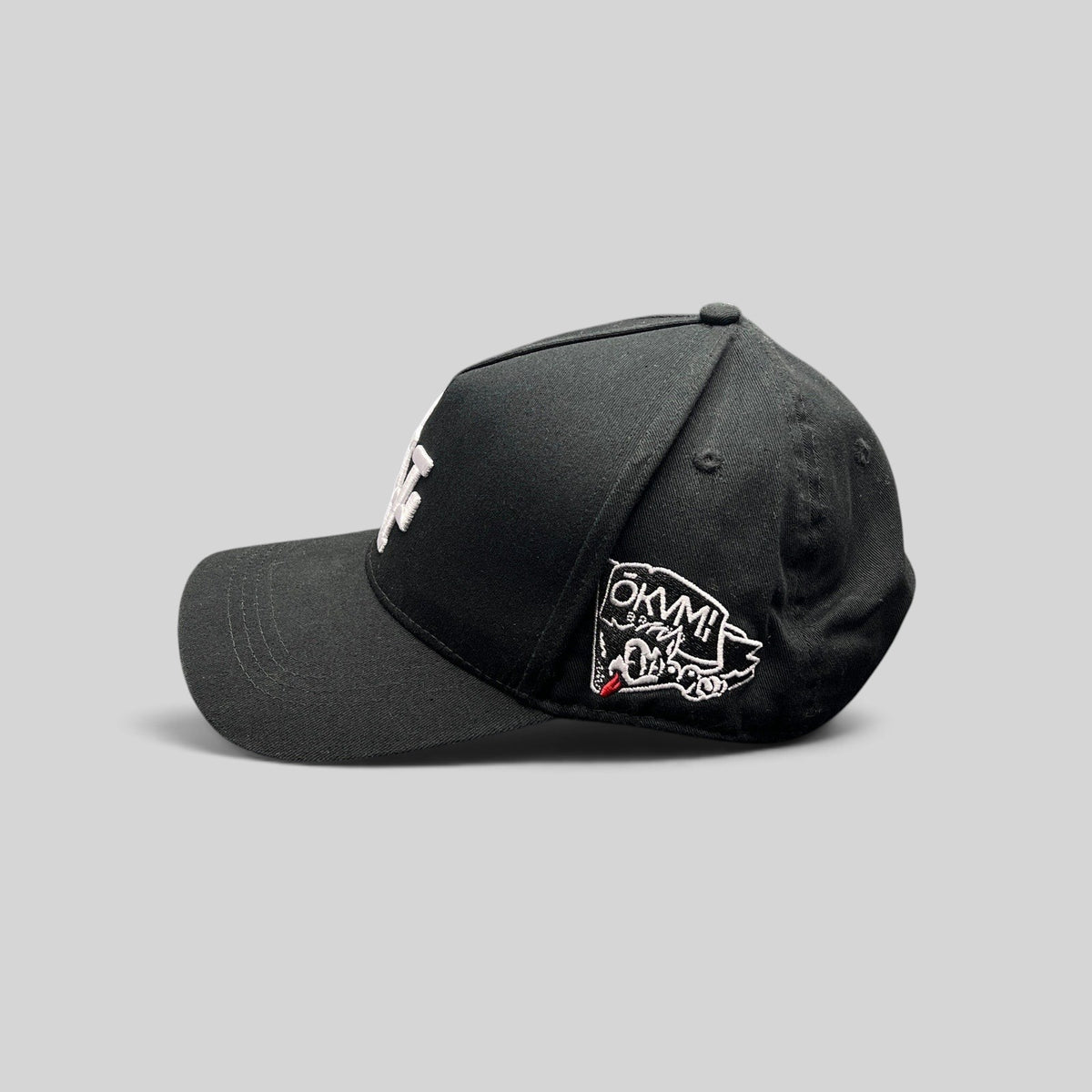 Raree Finds black Okami Brand strapback hat with white LV embroidery and side wolf graphic patch