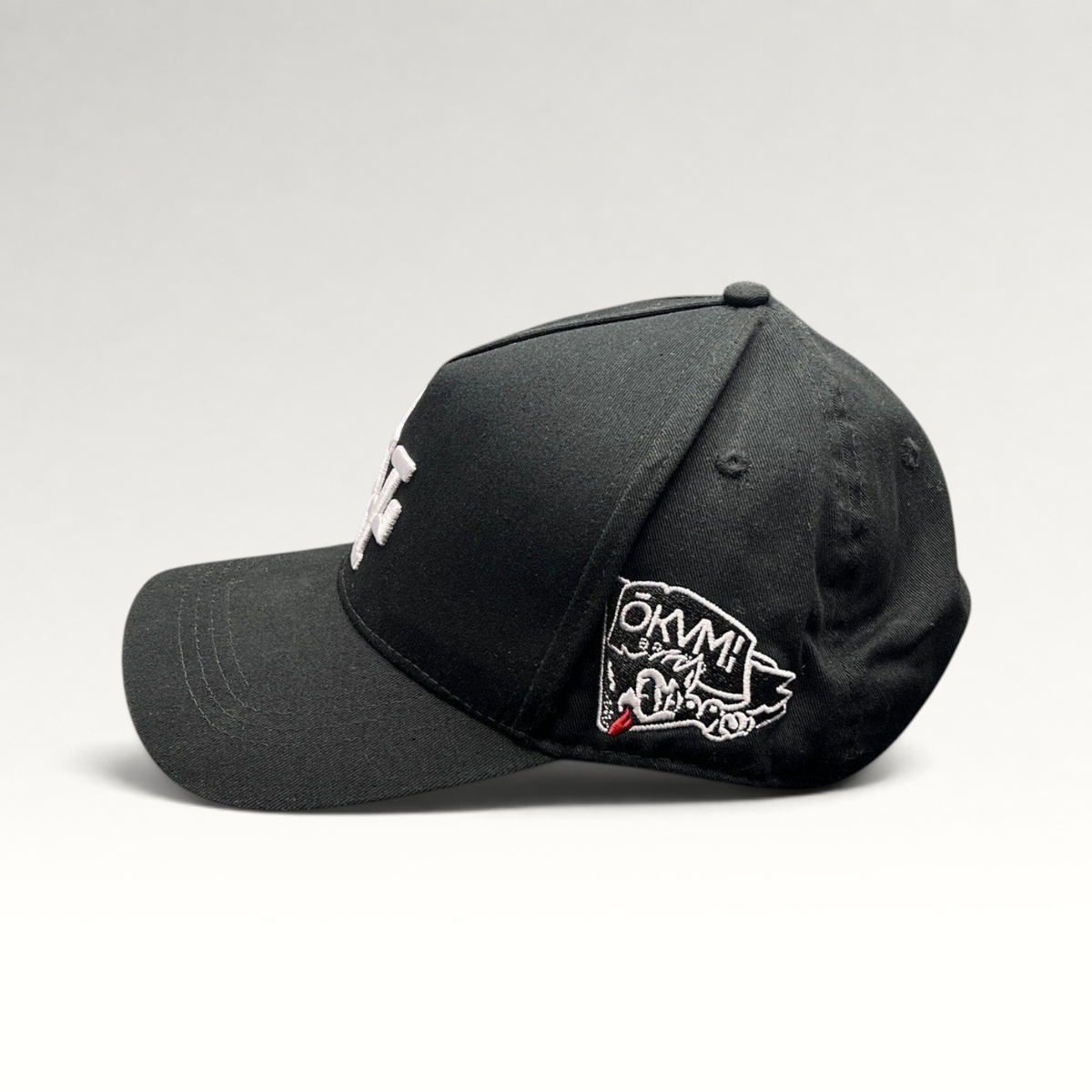 Raree Finds black Okami Brand strapback hat with white LV embroidery and side wolf graphic patch