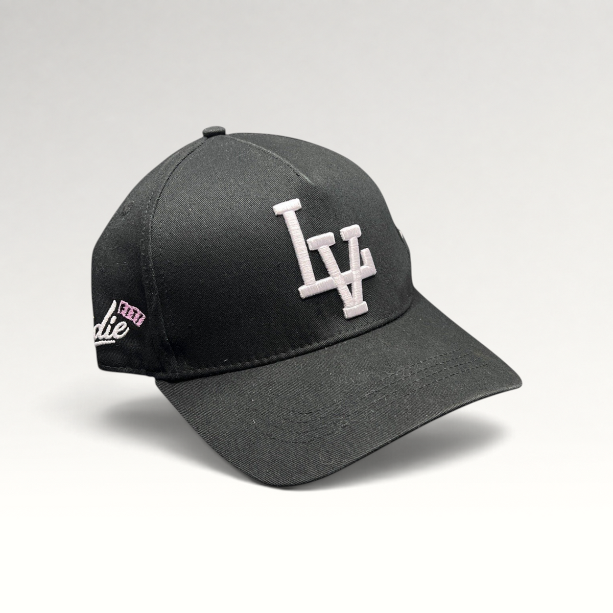 Raree Finds black Okami Brand strapback hat with white embroidered LV logo and side script detailing.
