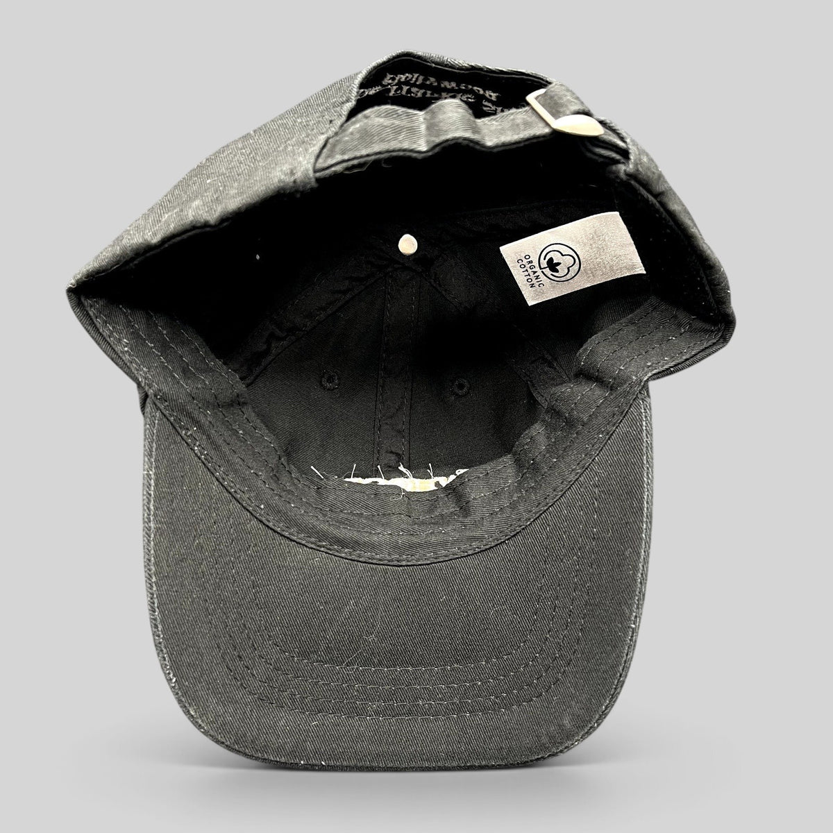 Raree Finds black organic cotton dad cap interior view showing the organic cotton label and adjustable strapback.