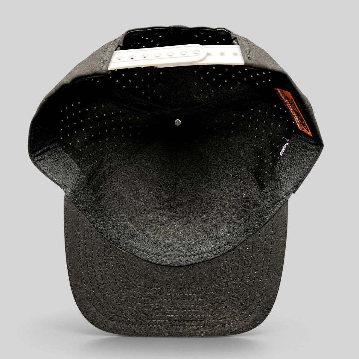 Raree Finds black snapback hat with perforated crown and white adjustable snap closure, interior view