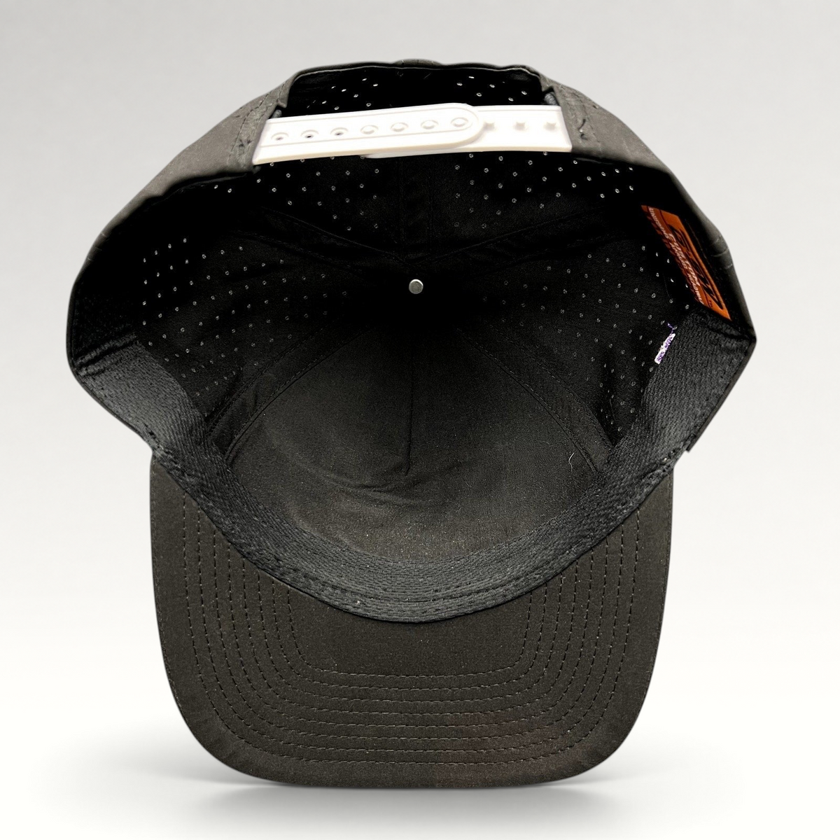 Raree Finds black snapback hat with perforated crown and white adjustable snap closure, interior view