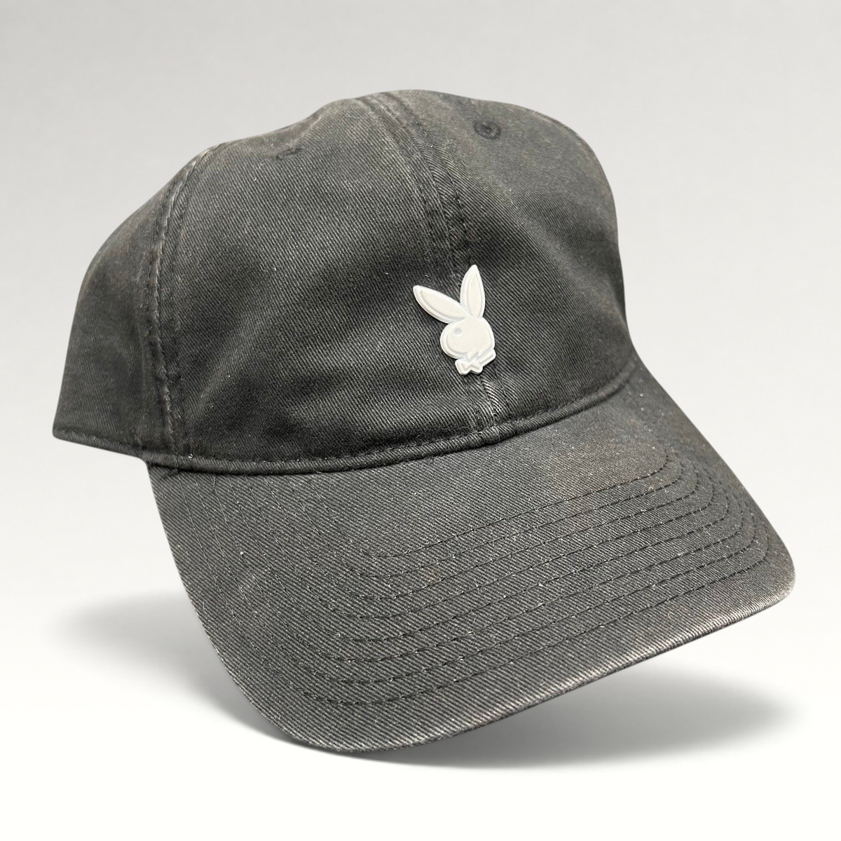 Raree Finds black cotton strapback hat featuring a minimalist silver metal Playboy bunny logo on the front crown