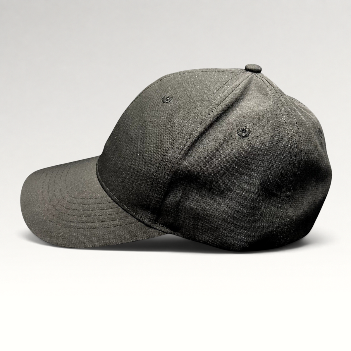 Raree Finds black polyester strapback hat with a curved brim and unstructured profile, side view.