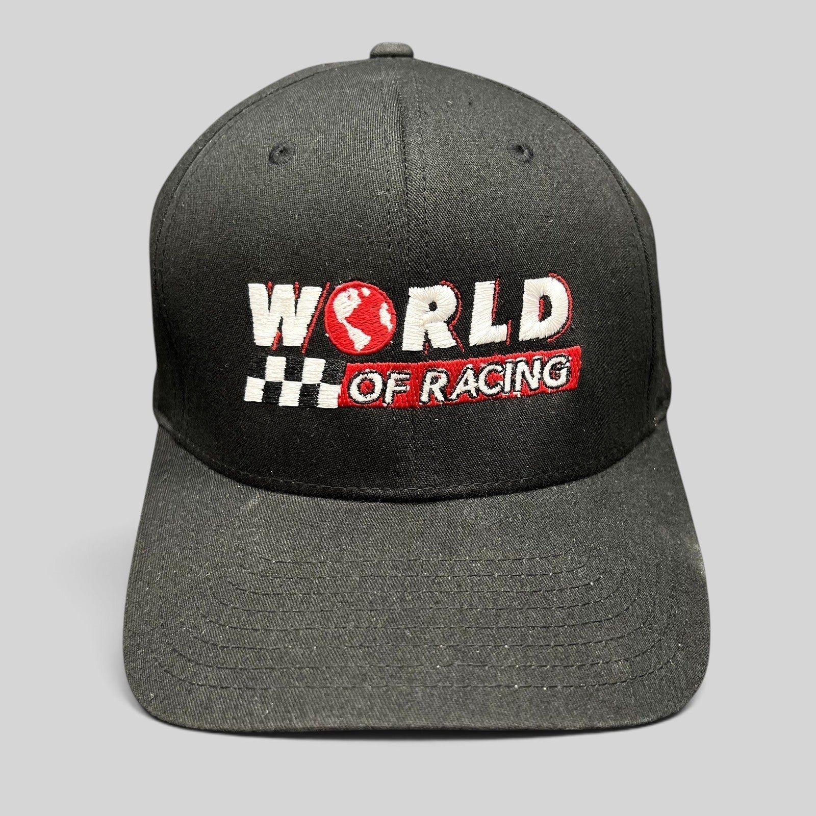 Raree Finds black Port Authority flexfit hat with embroidered World of Racing logo, checkered flag, and red globe icon.