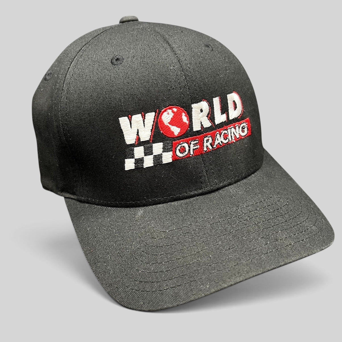 Raree Finds black Port Authority flexfit cap with World of Racing embroidery, checkered flag, and red globe icon.