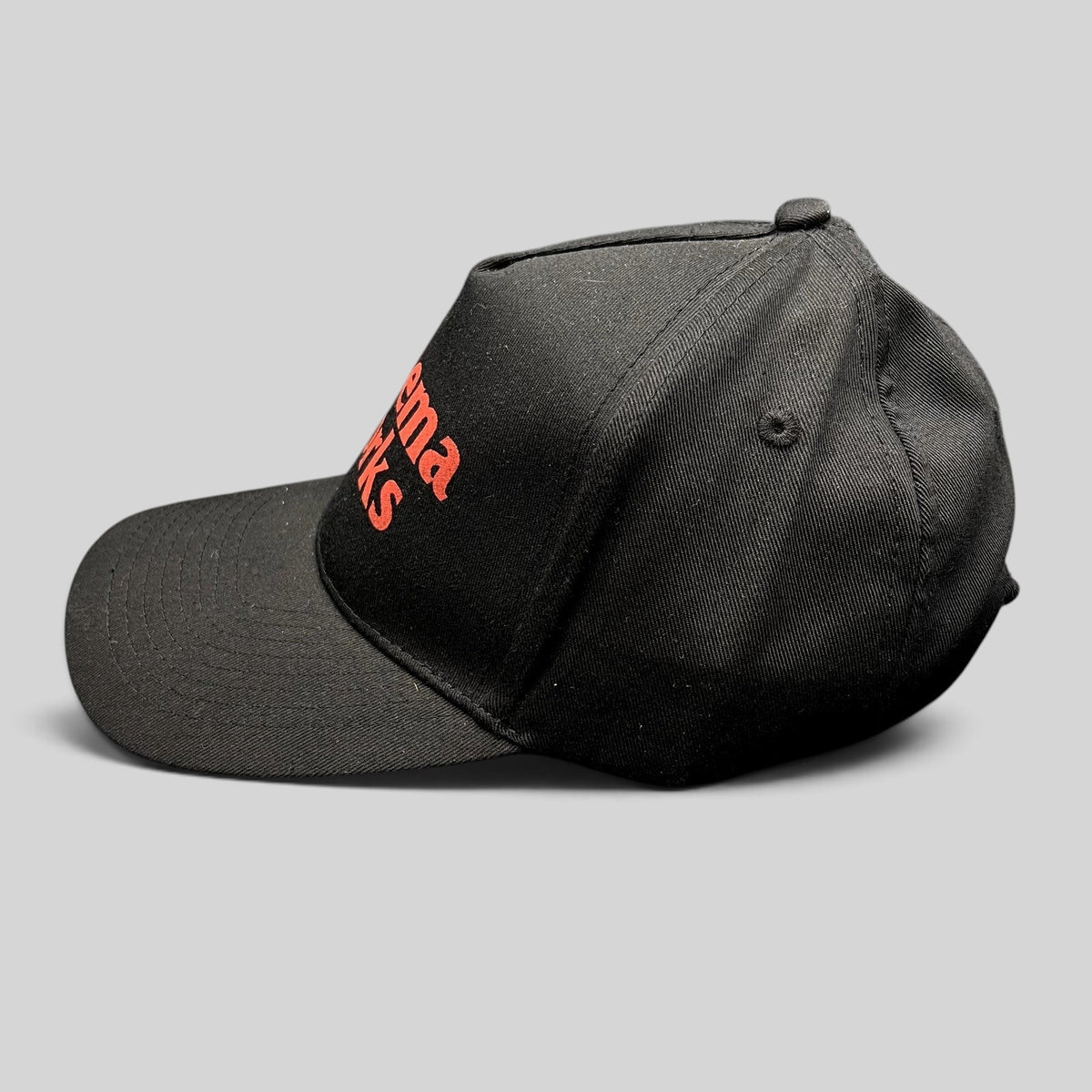 Raree Finds black cotton twill strapback hat with red CinemaWorks embroidery, side profile view.