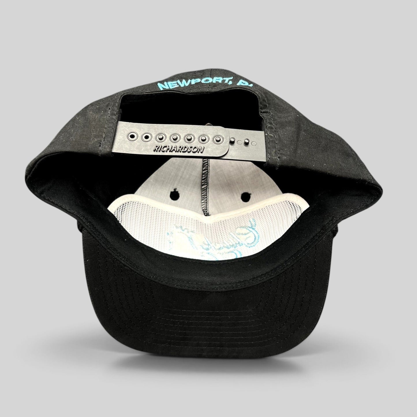 Raree Finds black Richardson Outdoor snapback hat showing the interior with Newport RI embroidery on the back strap
