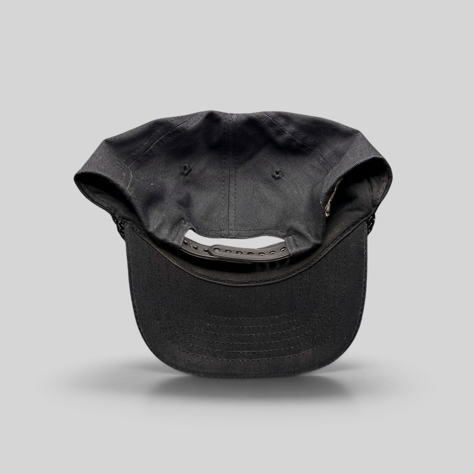 Raree Finds vintage black cotton snapback hat with rope trim and adjustable back closure, rear view.