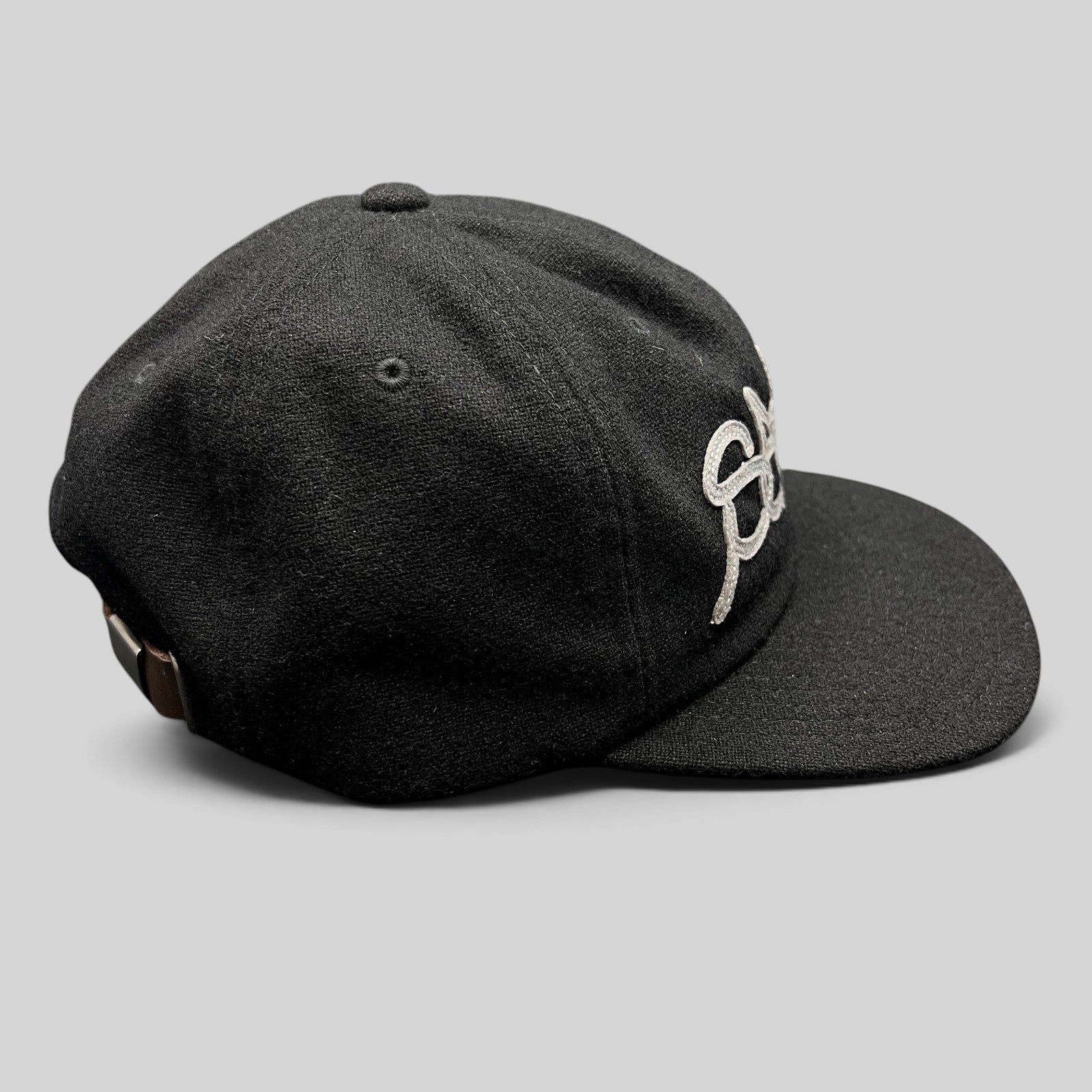 Raree Finds black Sake Brand strapback hat with gray embroidered script logo and leather strap closure