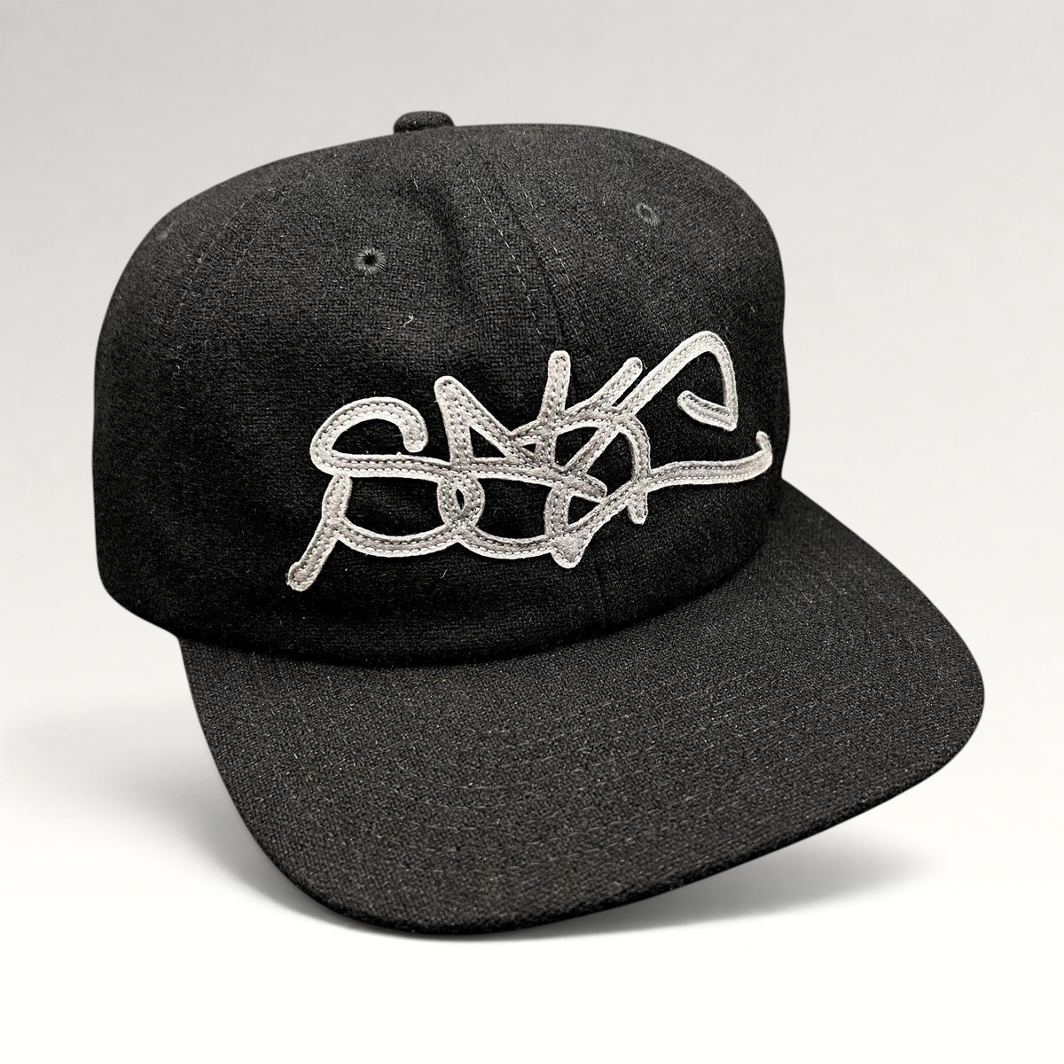 Raree Finds black Sake Brand strapback hat with oversized gray embroidered script logo and flat brim design